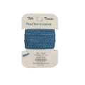 Blue yarn on a Tilly's Tomas Reflections label against a white background